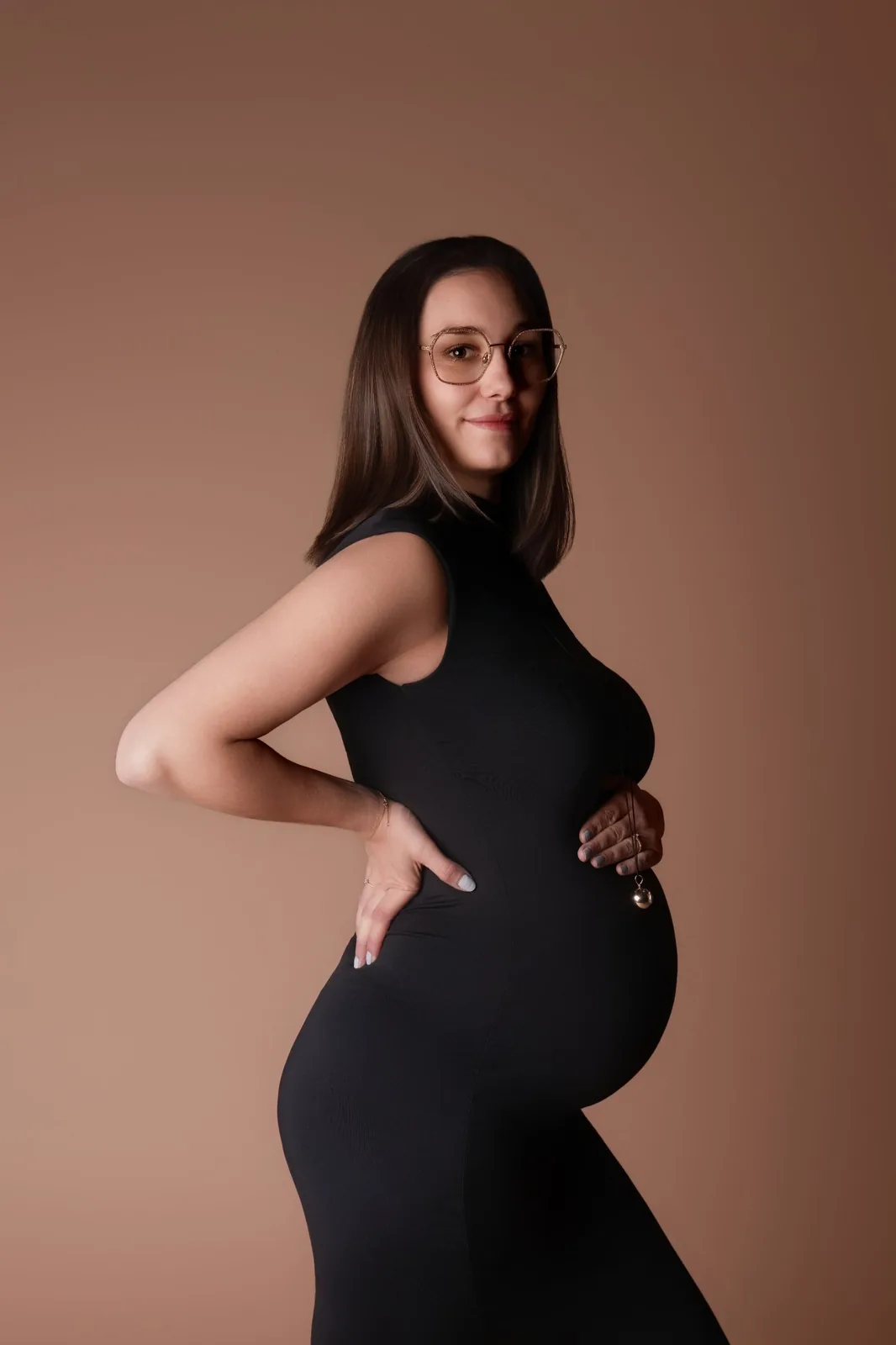 Future maman de profil en robe noire près du corps