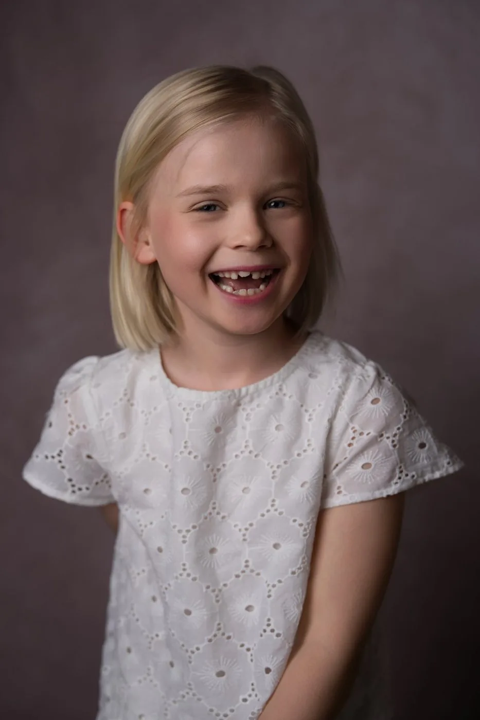 Fillette en blouse brodée qui éclate de rire