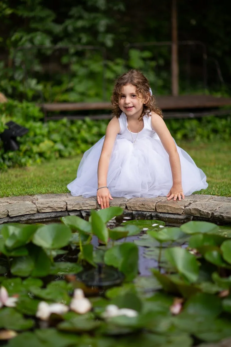 Petite fille en robe de tulle au bord d’un bassin