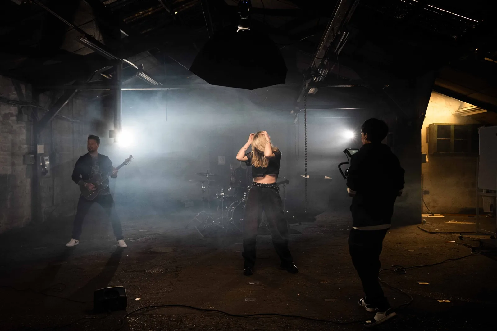 Tournage de clip musical dans un entrepôt, fumée et projecteurs