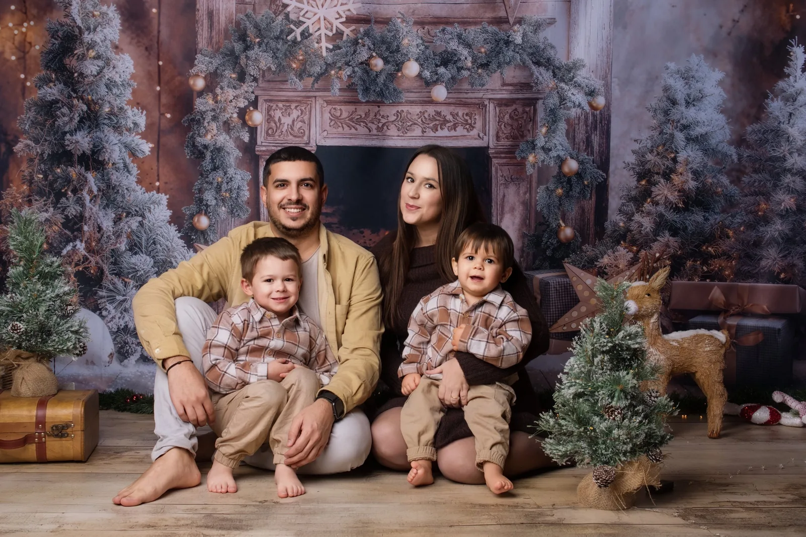 Famille et ses deux petits garçons devant un décor de Noël
