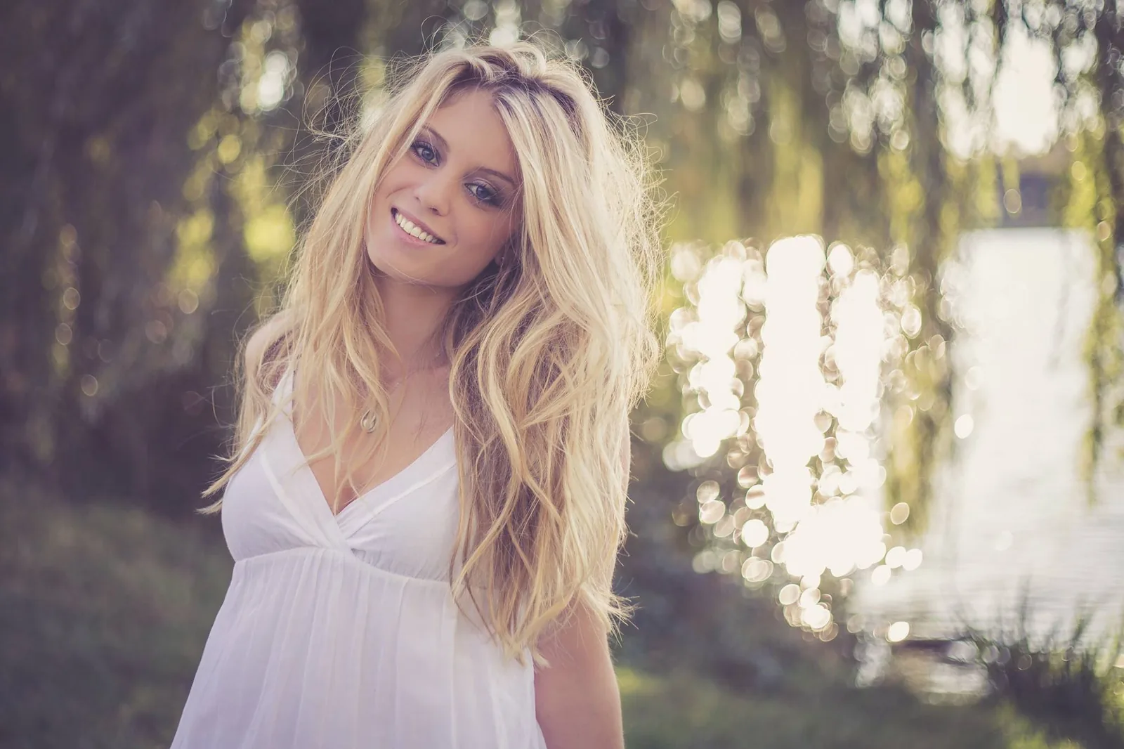 Sourire lumineux, cheveux blonds, bord de lac