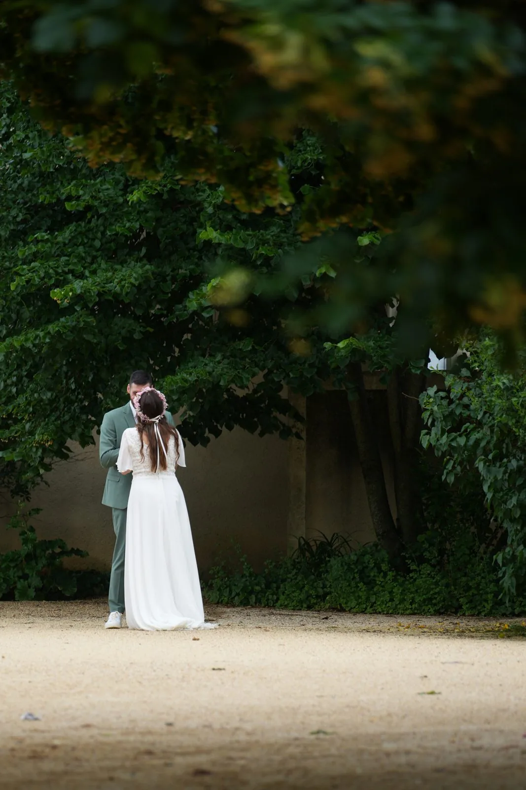 First look entre les mariés dans une allée arborée