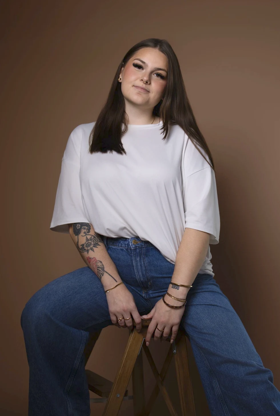 Jeune femme sur un tabouret en bois, regard confiant