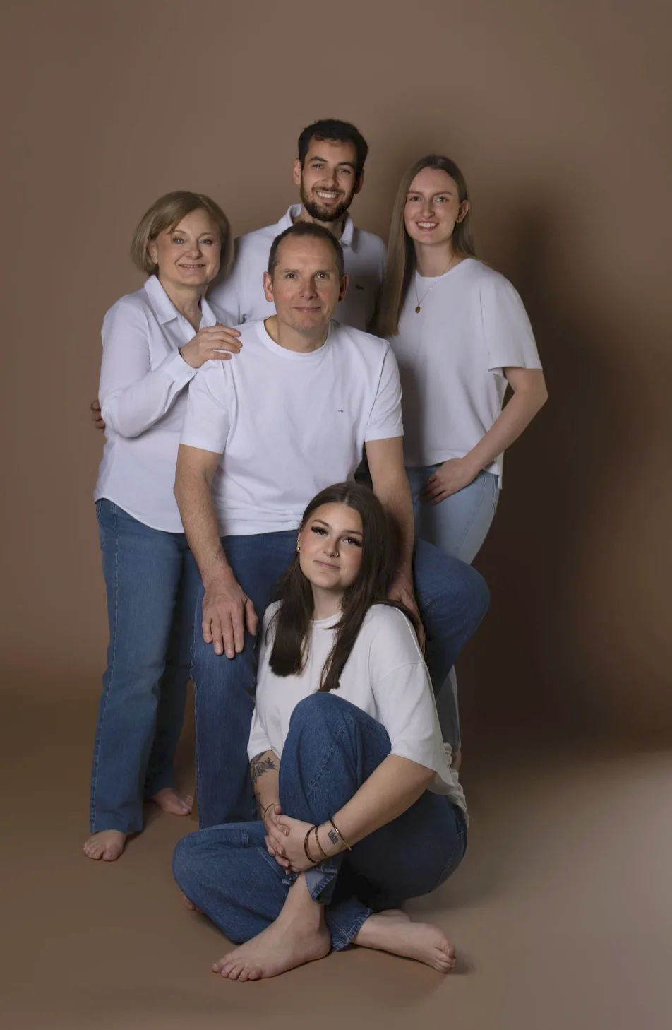 Portrait de famille, cinq adultes en blanc et jean, pieds nus
