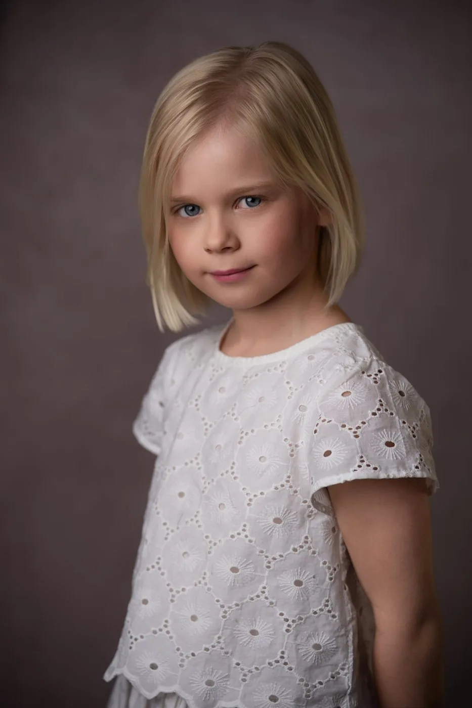 Portrait de fillette en blouse brodée blanche