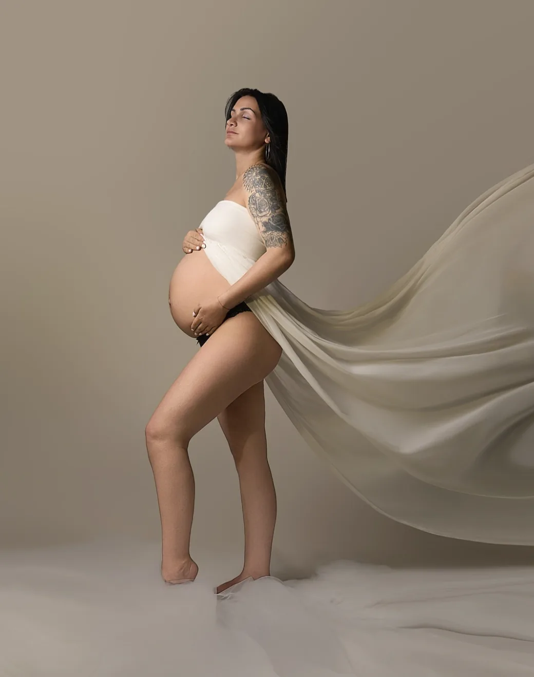 Future maman tatouée, voile crème en mouvement