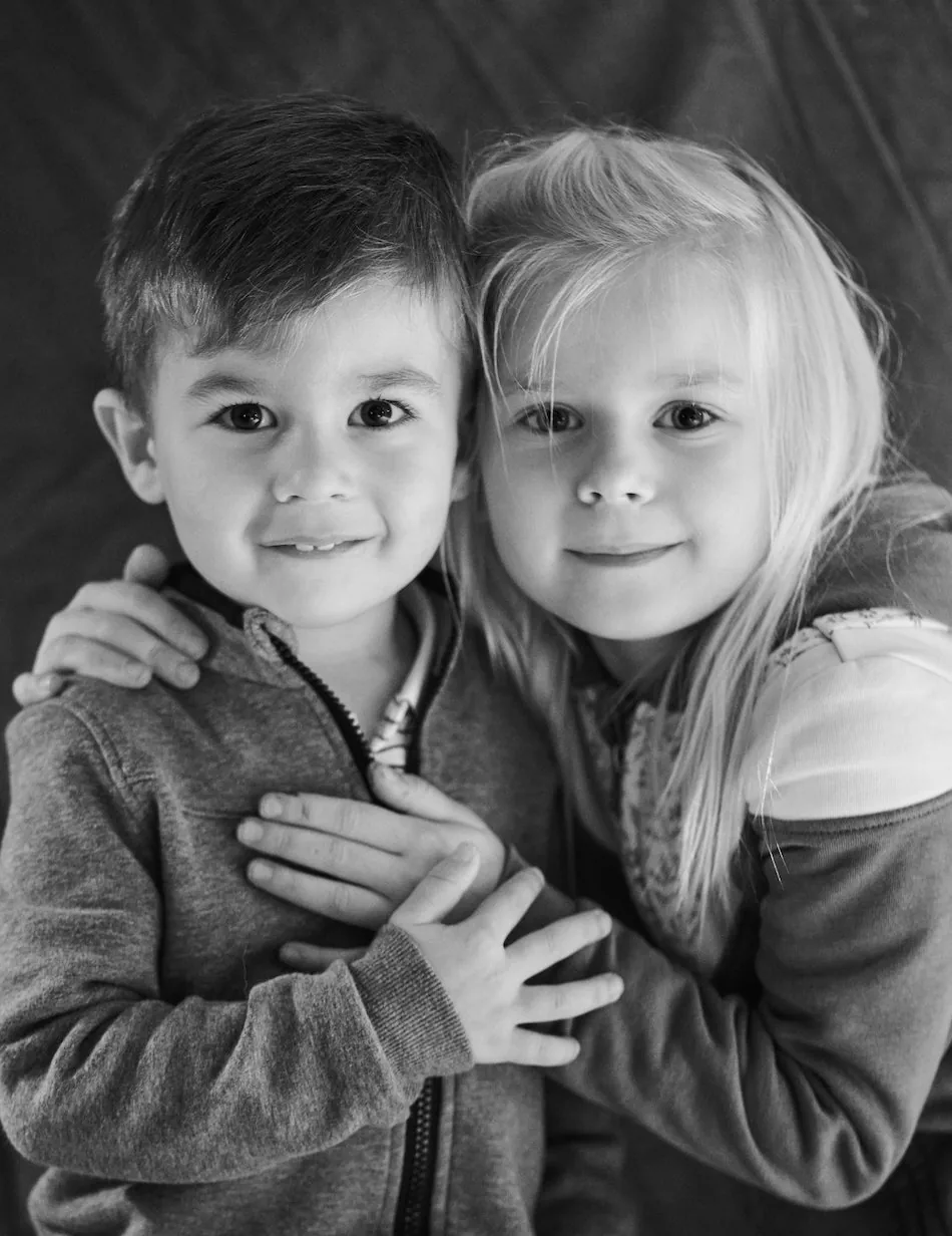 Un frère et une sœur joue contre joue, portrait noir et blanc