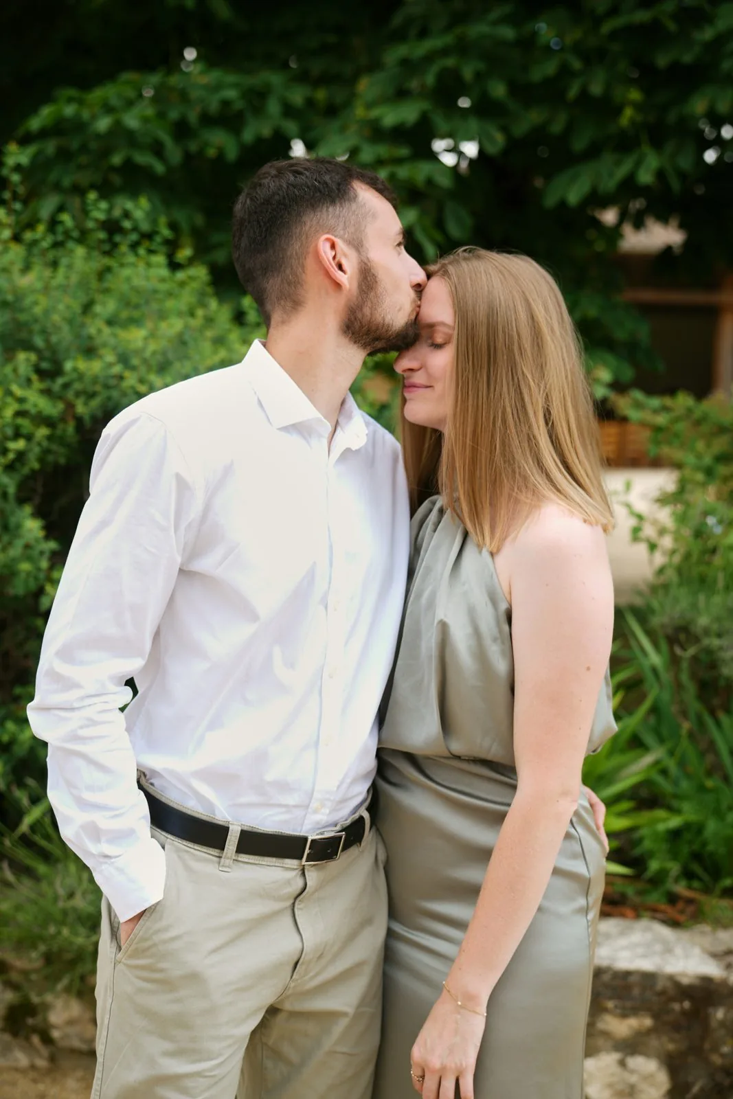 Un couple complice, elle sourit pendant qu'il l'embrasse sur la tempe